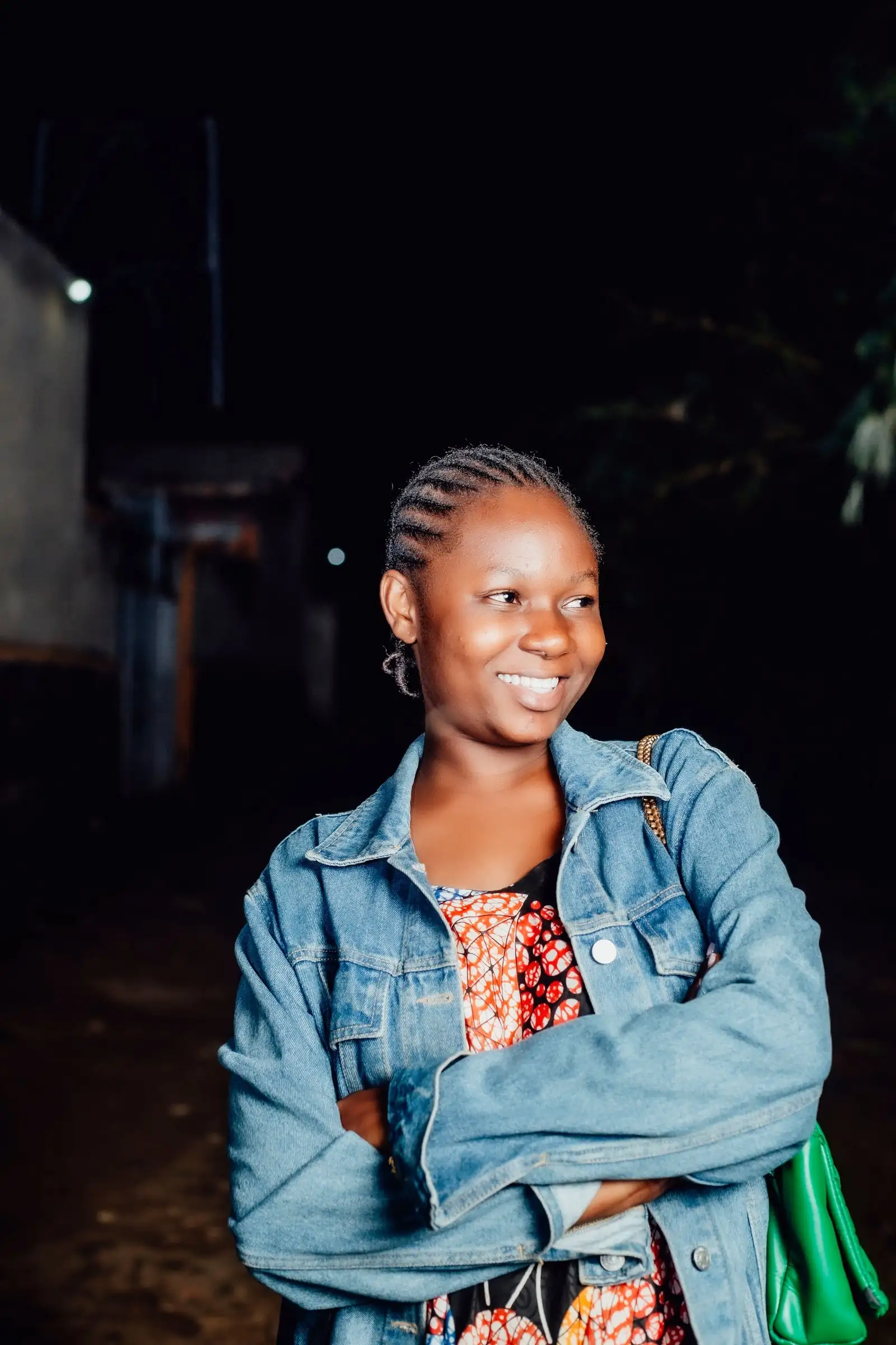 A young woman in a denim jacket, smiling